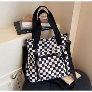 Detail of checkered tote bag with three zipper pockets and adjustable shoulder strap