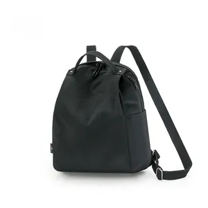 Detail of waterproof black nylon backpack showing top handle and embossed logo