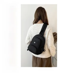 Detail of black waterproof crossbody bag showing multiple zip pockets and usage scenarios