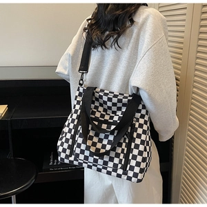 Detail view of checkerboard tote bag showing adjustable strap and large capacity texture