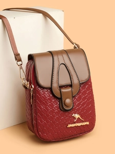 Close-up of woven texture and gold kangaroo logo on burgundy crossbody bag detail