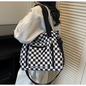 Detailed texture of checkerboard corduroy tote bag with side zippers and wide strap