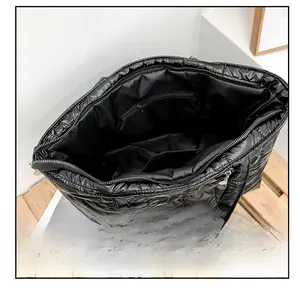 Detail view of the large black quilted tote bag interior with zipper pocket and lining