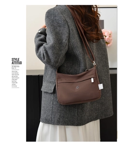 Side view of woman wearing deep brown nylon crossbody bag with wide shoulder strap