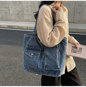 Detail of vintage denim tote bag with multiple pockets and adjustable shoulder strap
