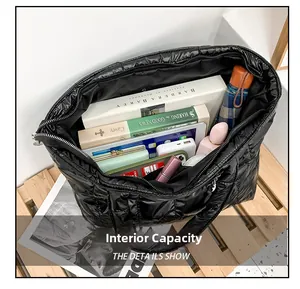 Spacious interior of black quilted tote bag showing storage for tablet and essentials
