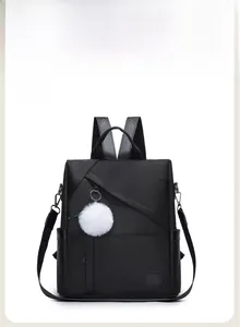 Front view of black Oxford backpack featuring a white faux fur charm and sleek zippers