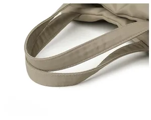 Detail of khaki nylon handbag showing reinforced handles and fine stitching quality