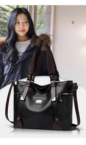 Détail du sac cabas en cuir noir à motif litchi avec anses marron et chaîne argentée