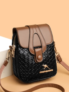 Detail of woven black leather mini crossbody bag with gold kangaroo logo and brown flap