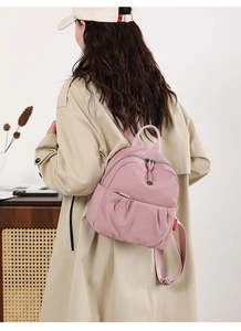 Detail of pink nylon mini backpack with silver zippers and lightweight waterproof fabric