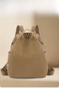 Detail shot of khaki water-resistant nylon backpack with branding and side pocket