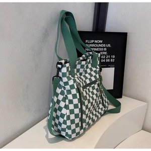 Detail of green checkerboard tote with corduroy texture and vertical zipper pockets