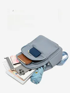 Détails du rangement intérieur avec tablette et objets dans un sac à dos bleu clair