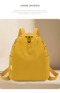 Detail view of water-resistant yellow nylon backpack with RUI&MU logo and side pocket