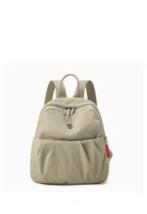 Detailed front view of beige pleated oxford canvas backpack with red side label accent