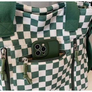 Detail of green checkerboard corduroy tote bag showing front zipper pockets and texture