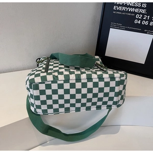 Detail of green and white checkered tote bag with durable fabric strap and side zipper