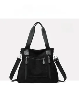 Detail of black large tote bag with multiple zipper pockets and adjustable strap