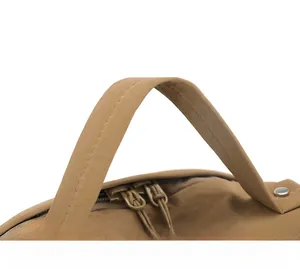 Macro detail of comfortable brown nylon handle and dual zipper stitching on the backpack