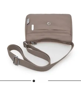 Flat lay showing details of the khaki waterproof nylon crossbody bag with zipper compartments