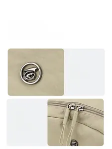 Detail of light beige canvas backpack featuring round metal logo and smooth dual zippers