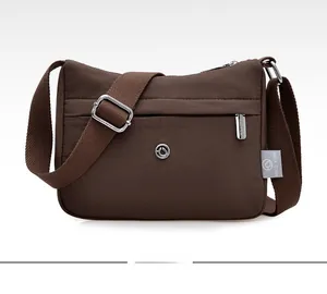 Detailed front view of brown nylon crossbody bag with zipper pockets and logo