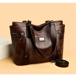 Détail du grand sac cabas marron foncé avec texture cuir, zips latéraux et logo métallique