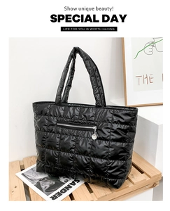 Macro detail of black quilted tote bag showing padded texture and front zipper pocket