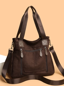 Detailed view of large brown suede tote bag with zipper pockets and nylon strap