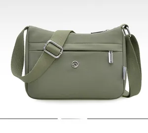 Detailed front view of olive green waterproof nylon crossbody bag with multi-zipper pockets