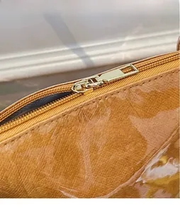 Detailed close-up of golden metal zipper and textured brown tyvek tote bag fabric