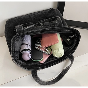 Close-up showing the spacious interior and denim texture of this black tote bag
