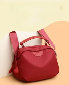 Close-up of waterproof burgundy nylon fabric showing scratch-resistant texture and handle detail