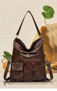 Detail view of large brown vintage leather tote with multi-pockets and metal buckles