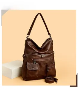 Detail of dark brown faux leather tote bag with functional pockets and metal zippers