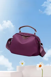Lightweight purple nylon crossbody bag with brown leather handles weighing 0.23KG