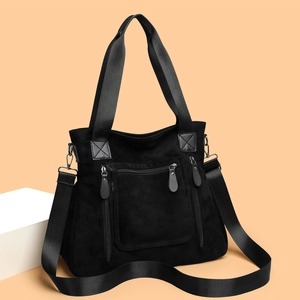 Large black suede tote bag with multiple zipper pockets and adjustable shoulder strap
