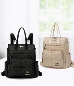 Detail view of quilted nylon backpack featuring metallic kangaroo logo and dual zip pockets
