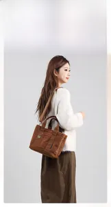 Borsa tote marrone in pile con tracolla regolabile ed etichetta con logo inciso