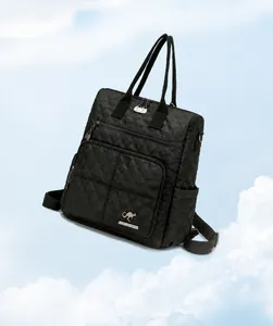 Detail of black quilted nylon backpack featuring golden logo and 0.41kg lightweight design