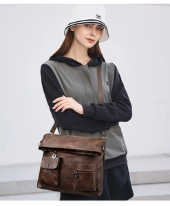 Detail of dark brown leather tote bag with flap design and metal logo hardware detail