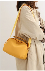 Side view of yellow oxford crossbody bag with wide strap on model for size reference