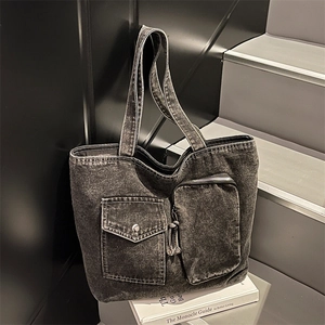 Black washed denim tote bag with multi-pocket utility design and shoulder strap