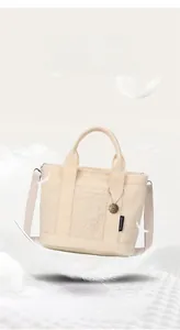 Dettaglio ravvicinato della borsa tote in pile teddy crema con spalline imbottite morbide