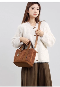 Borsa tote in pile marrone indossata da una modella, perfetta per l'autunno con tracolla