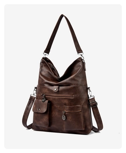 Detail of vintage brown tote bag showing multiple functional pockets and antique hardware