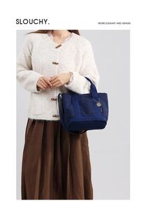 Dettaglio della borsa in pile blu scuro con tracolla regolabile e ciondolo in metallo