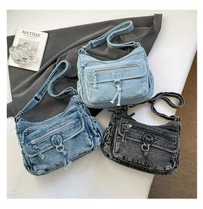 Detailed view of layered denim crossbody bags with zippers and adjustable straps
