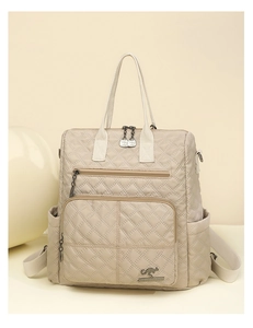 Detailed view of the quilted nylon texture and multi-pocket design on this beige backpack
